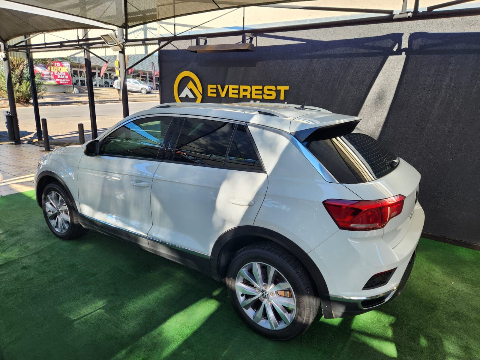 White 2021 Volkswagen T-Roc 1.4 TSI Design Auto, rear left three-quarter exterior view at the dealership.
